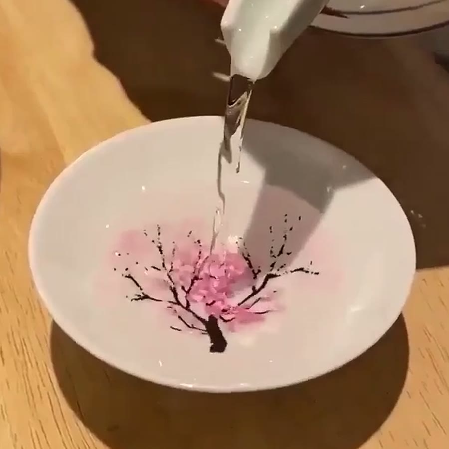 Cold sake being poured in: the first pink blossoms appearing on the branches
